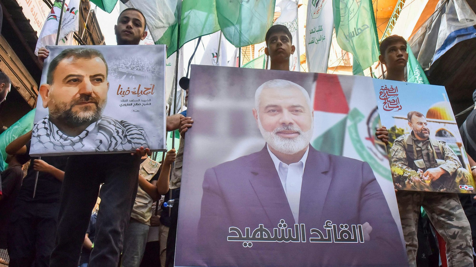 Demonstranten schwenken Fahnen und halten Bilder des Führers der militanten palästinensischen Hamas-Gruppe, Ismail Haniyeh, (C) und des hochrangigen Führers Saleh al-Arouri während einer Demonstration am 31. Juli 2024.
