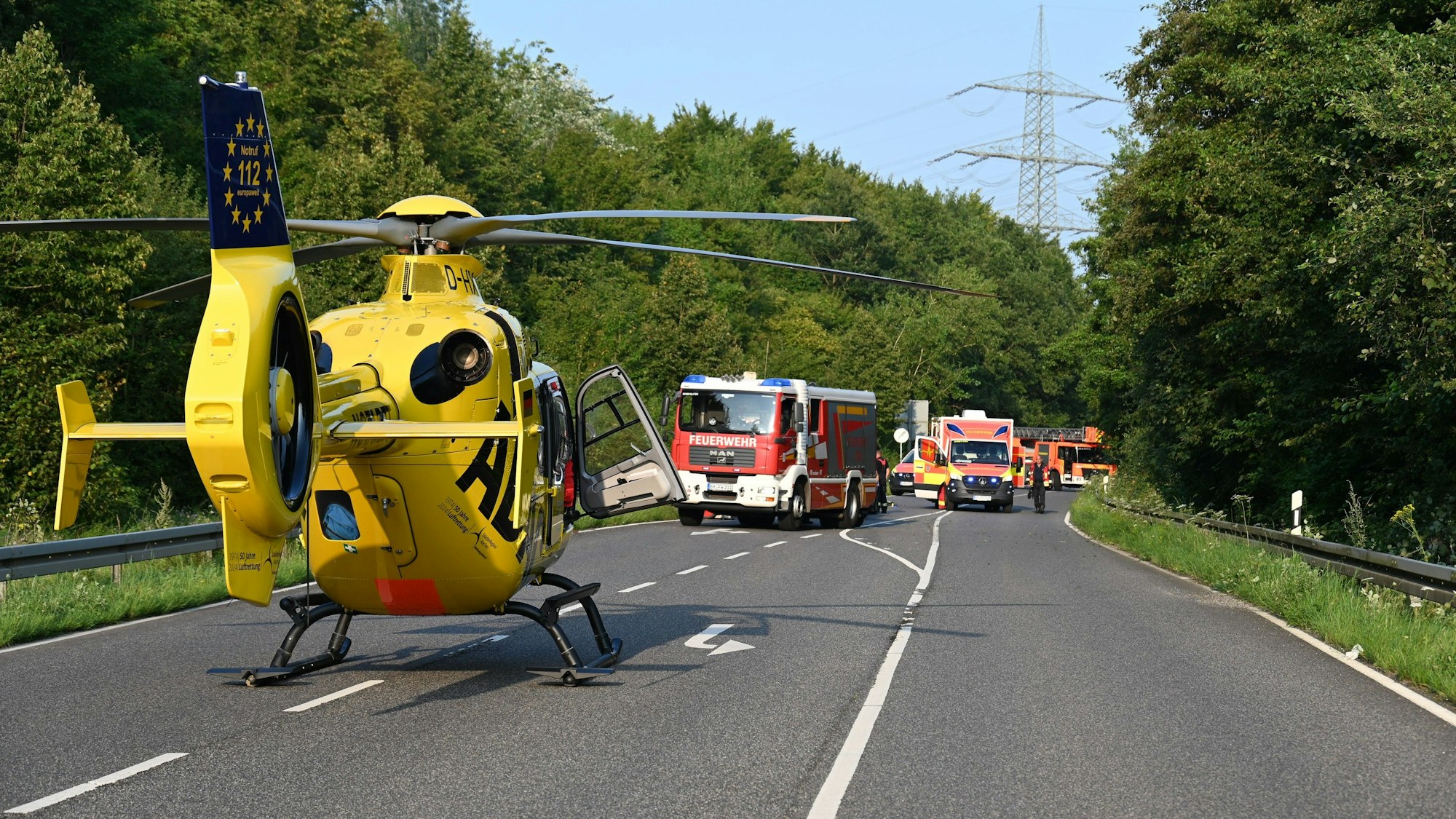 Ein Rettungshubschrauber steht auf einer Landstraße.