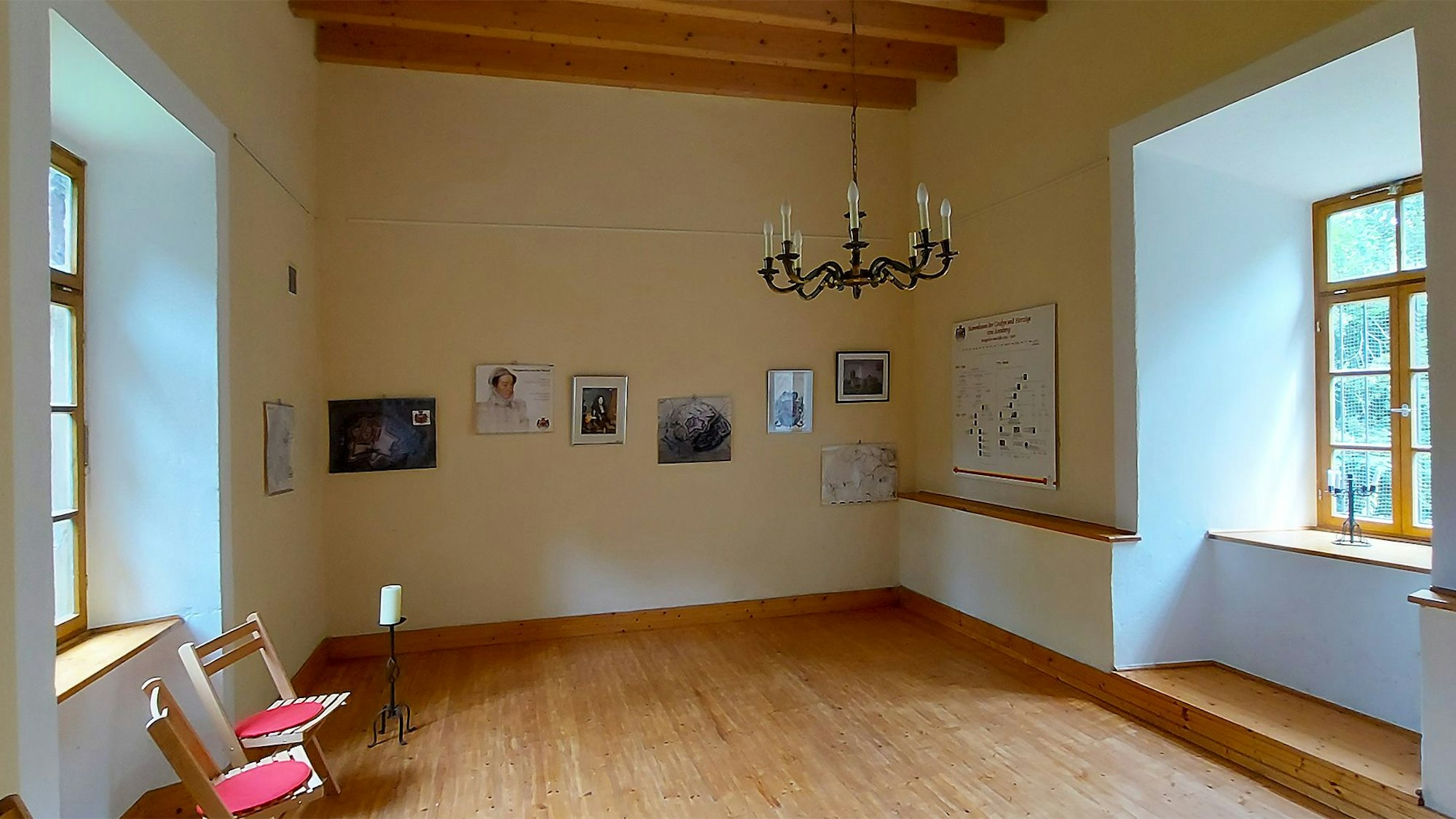 Das Bild zeigt einen Raum mit Parkett und Kronleuchter in einem Turm.