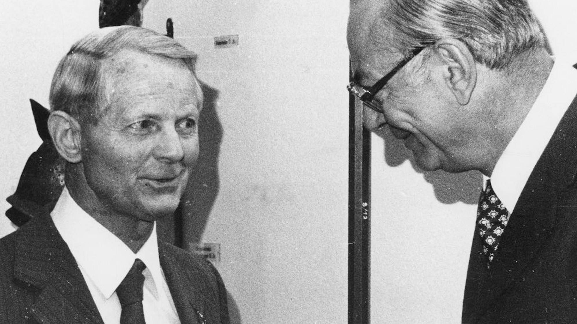 Ein Mann überreicht einem anderen eine Medaille.