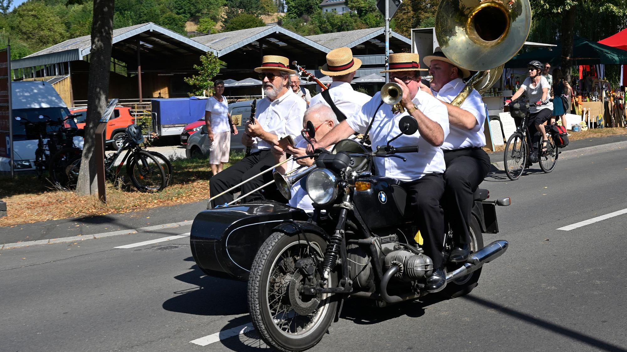 Vier Divieland-Musiker fahren auf einem Motorrad mit Beiwagen in Bergisch Gladbach-Herrenstrunden.