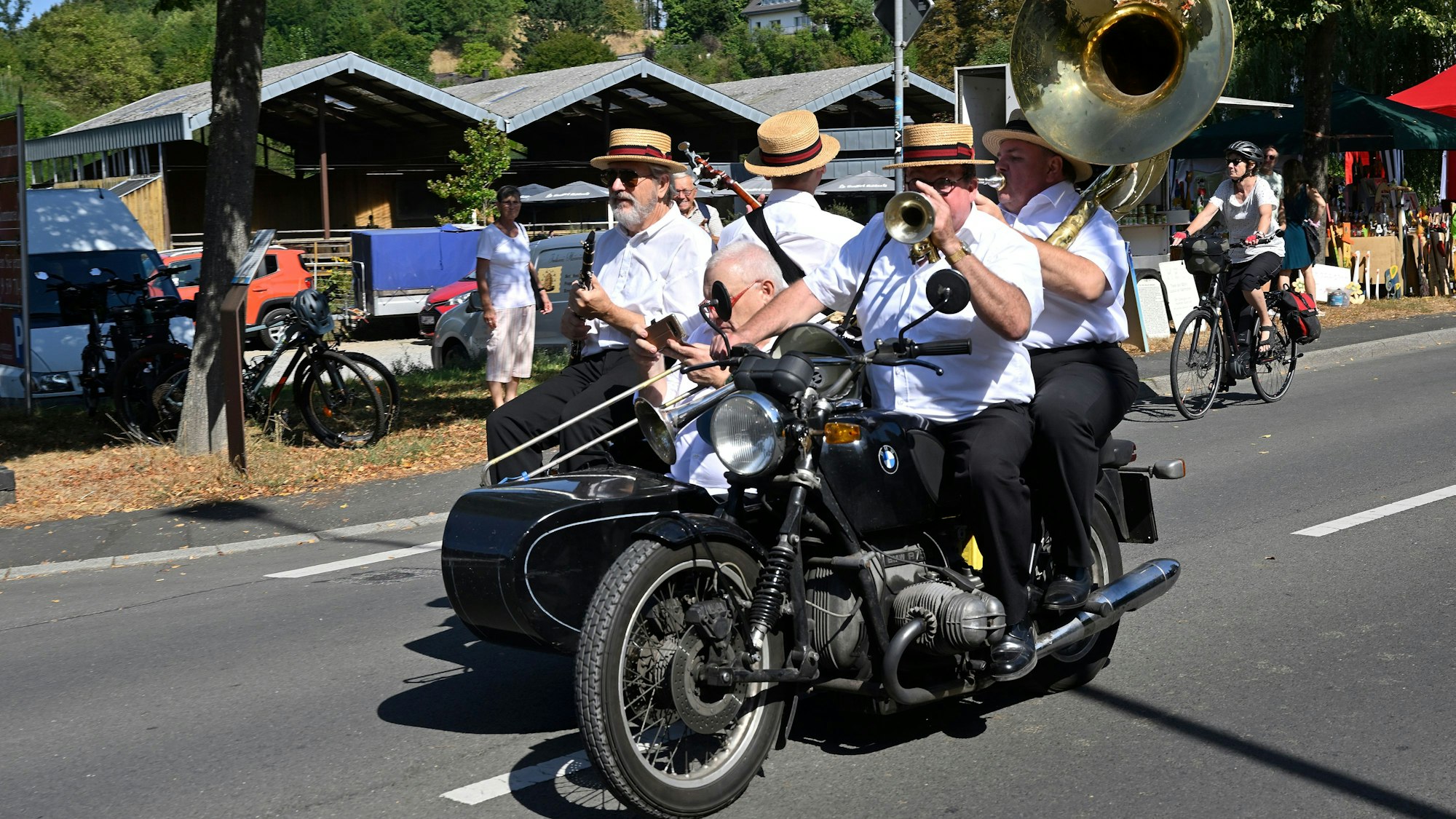 Vier Divieland-Musiker fahren auf einem Motorrad mit Beiwagen in Bergisch Gladbach-Herrenstrunden.