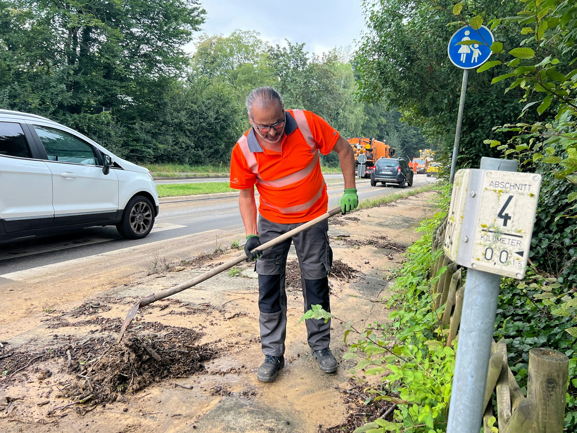 Ein Mitarbeiter von Straßen NRW räumt nach dem Starkregen auf.