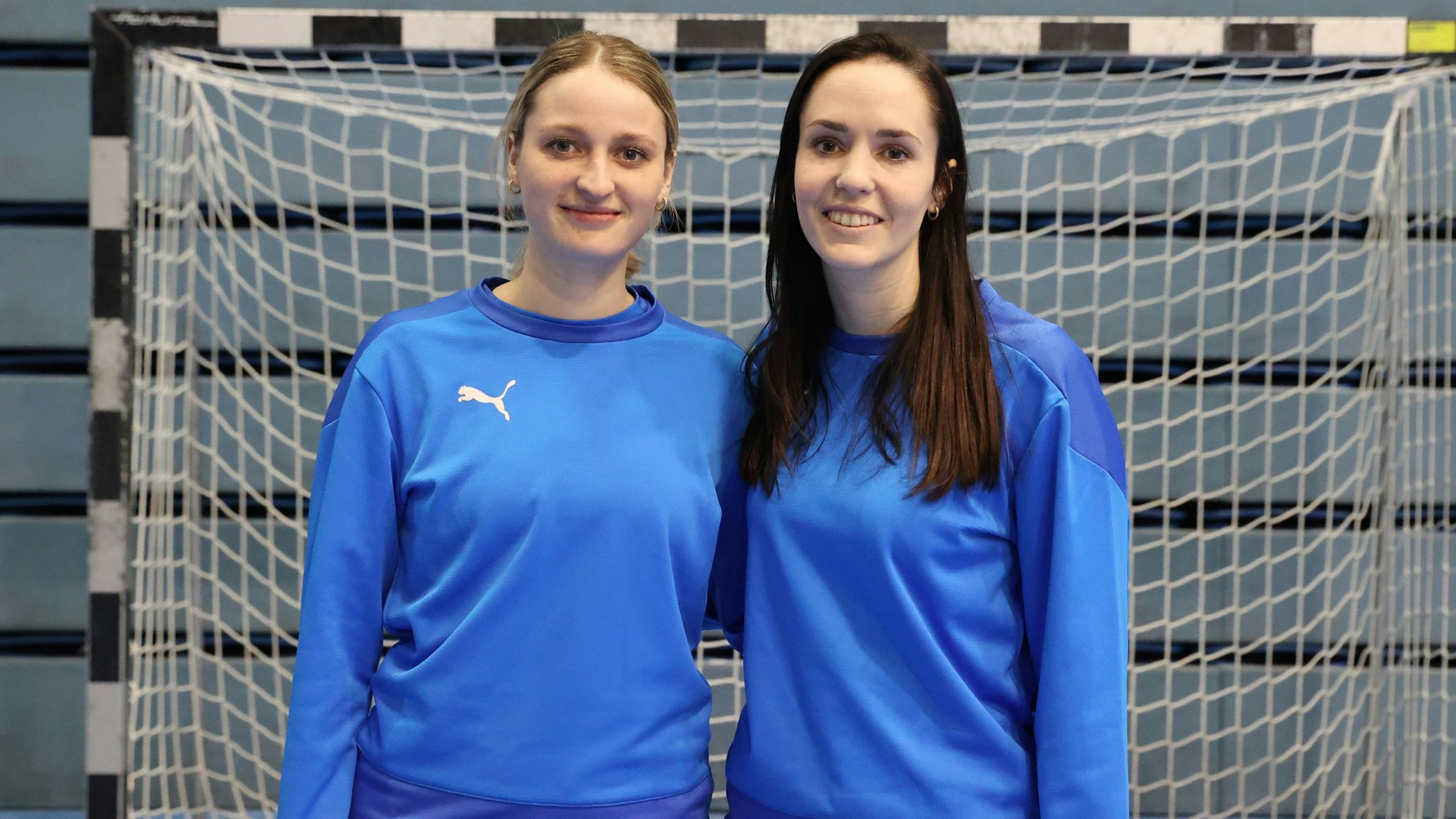 Zu sehen sind zwei Frauen vor einem Handballtor.