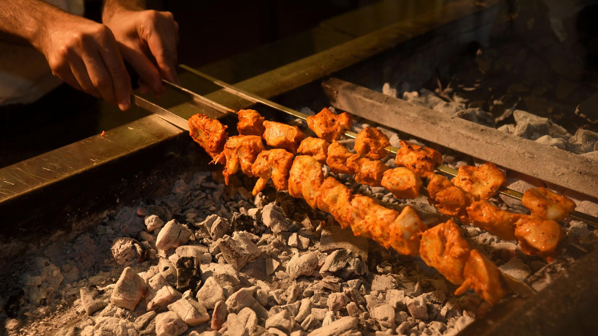 Fleischspieße auf einem Holzkohlengrill.