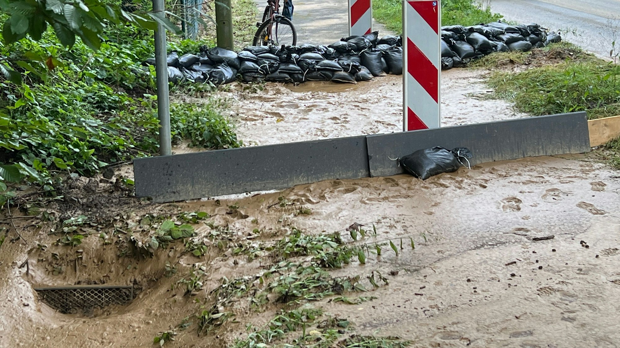 Der Ablauf neben der L294 (in der Bildecke links unten) war überfordert. Aufräumen und Fazit-Ziehen war nach der kurzen aber heftigen Sturzflut vom Donnerstag angesagt. Foto: Ralf Krieger