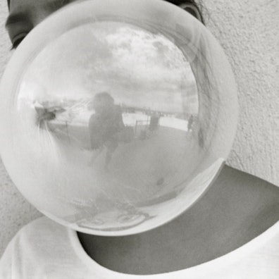 Eine Kaugummiblase verdeckt die Person dahinter. Dafür sieht man die gespiegelte Fotografin.