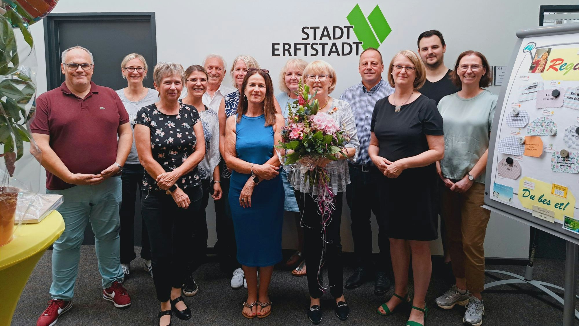 Männer und Frauen stehen in einem Raum.