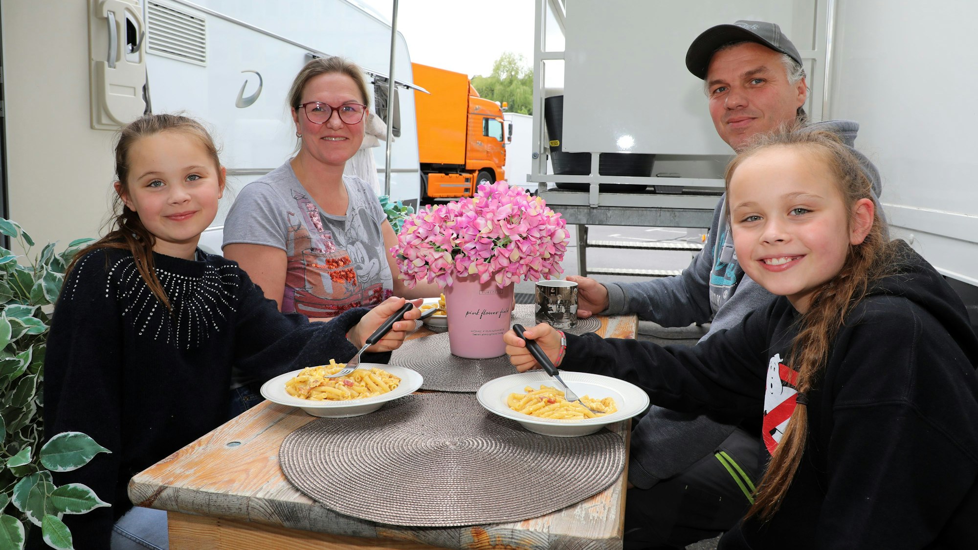 Die Schaustellerfamilie Nadine Luxem, Thomas Luxem und die Zwillinge Bobbi (l.) und Coco Schaar sitzen vor ihrem Wohnwagen bei der Bergisch Gladbacher Kirmes.