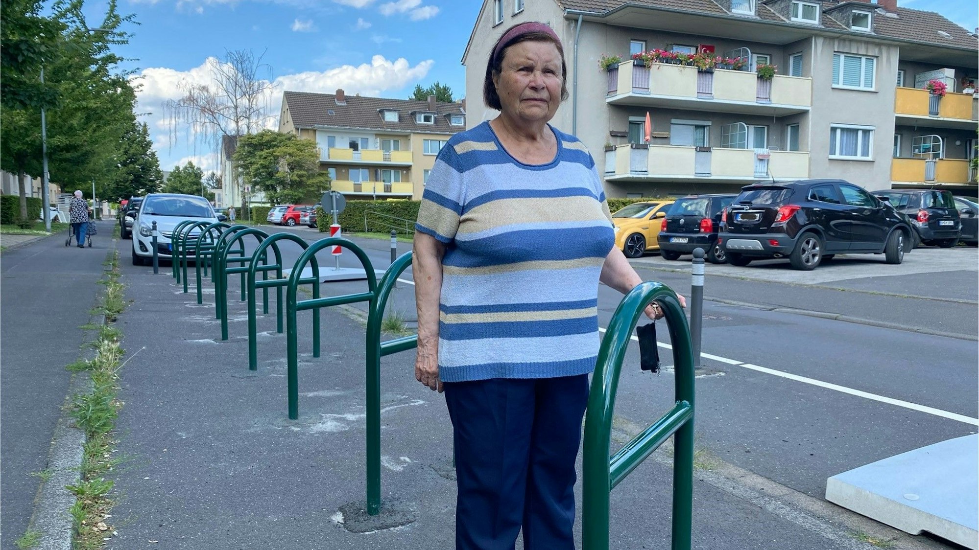 Auf dem Foto ist Marianne Hermann aus Brühl zu sehen. Sie steht zwischen den Metallbügeln, an denen Fahrräder abgestellt werden sollen. Aber kein einziges Rad steht dort.