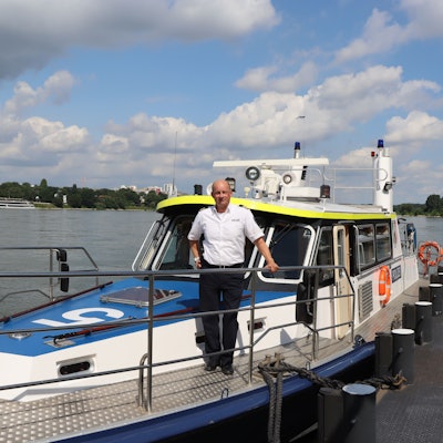 Ein Wasserschutzpolizist steht auf einem Boot.