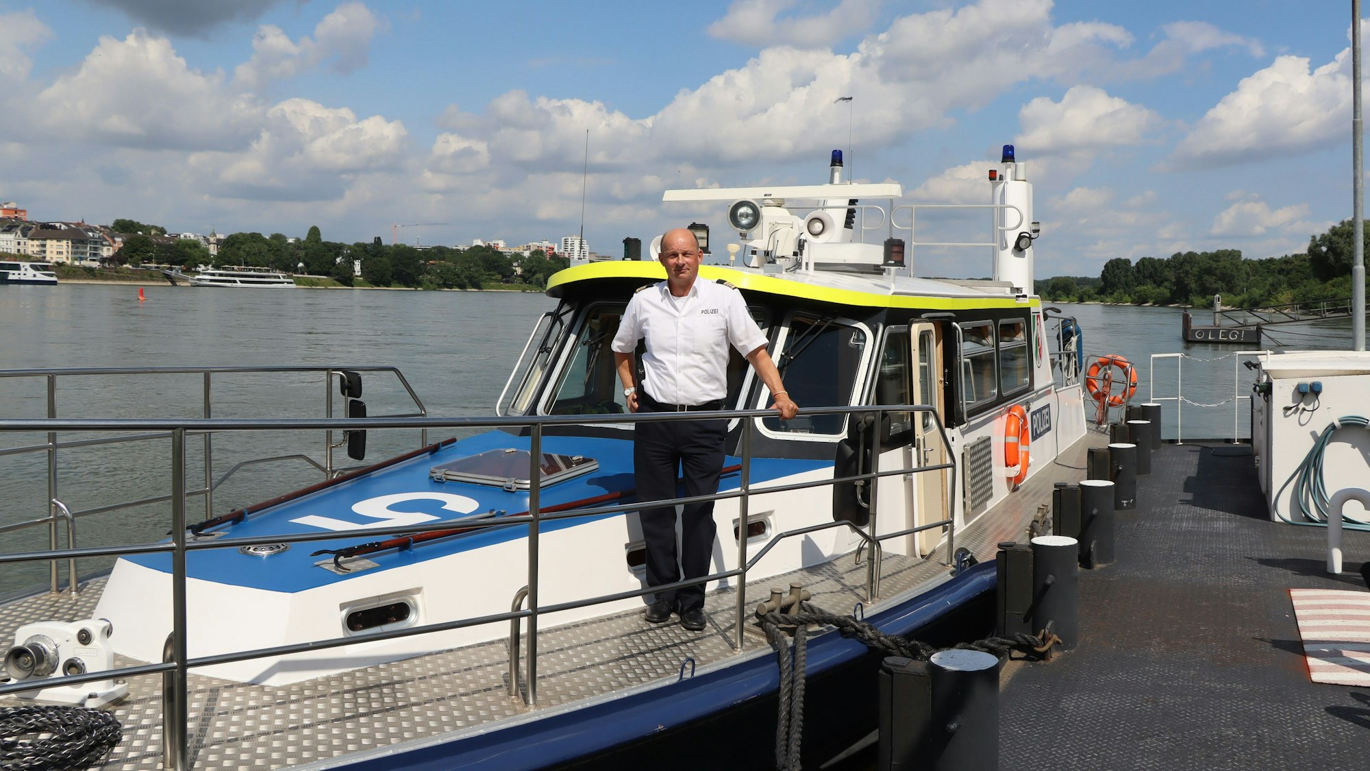 Ein Wasserschutzpolizist steht auf einem Boot.