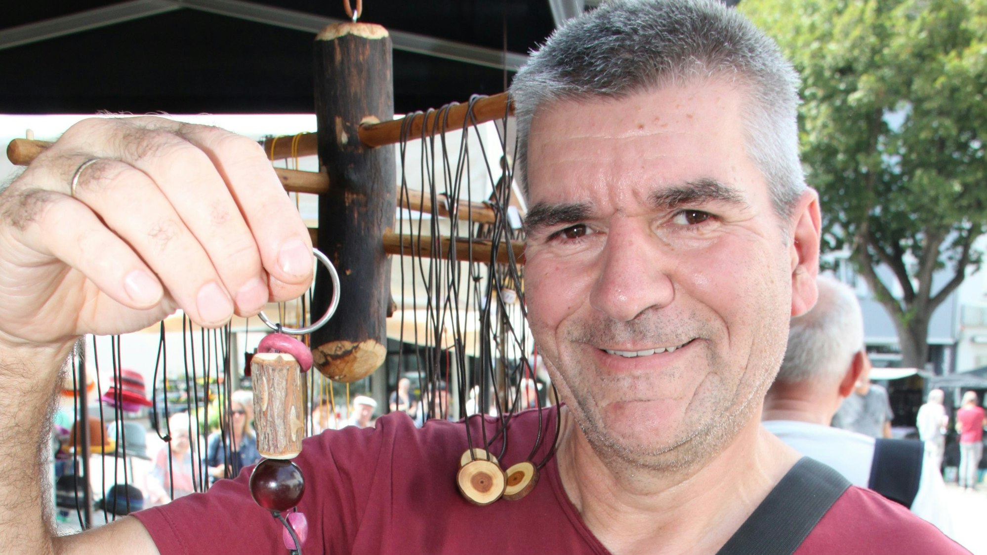 Günter Jakob Roesch zeigt einen seiner Schlüsselanhänger aus Holz.