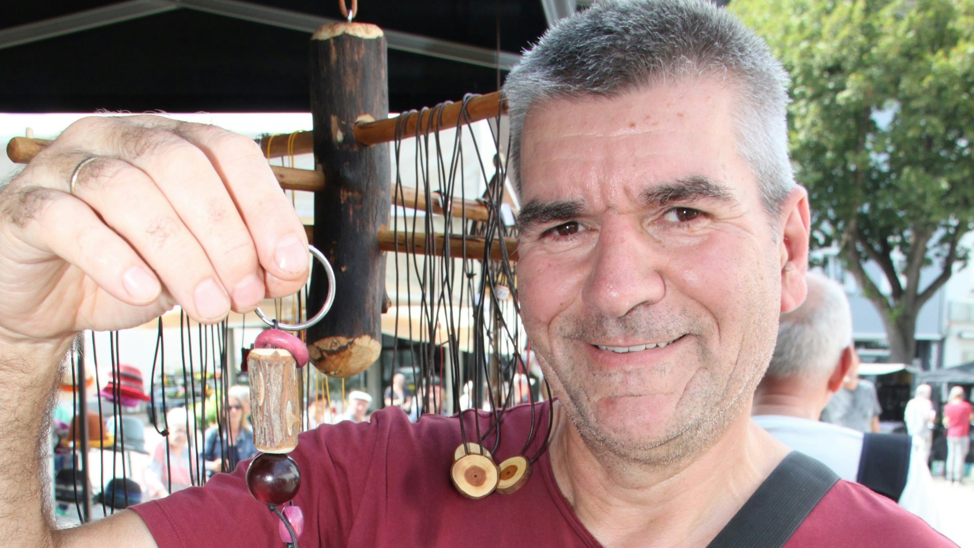 Günter Jakob Roesch zeigt einen seiner Schlüsselanhänger aus Holz.