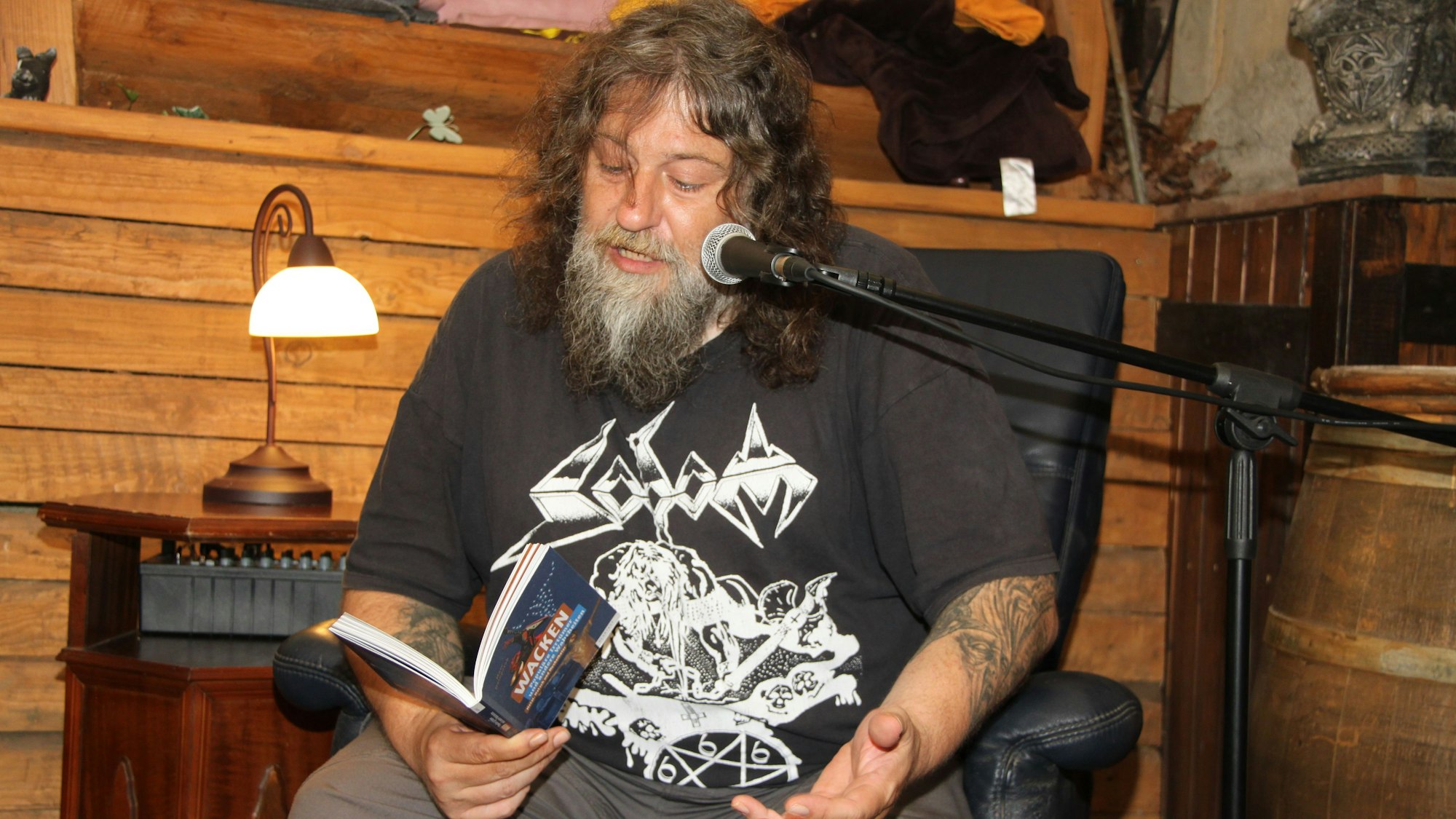 Der Autor Till Burgwächter sitzt in der Satzveyer „Burgbäckerei“ und liest aus einem seiner Bücher.