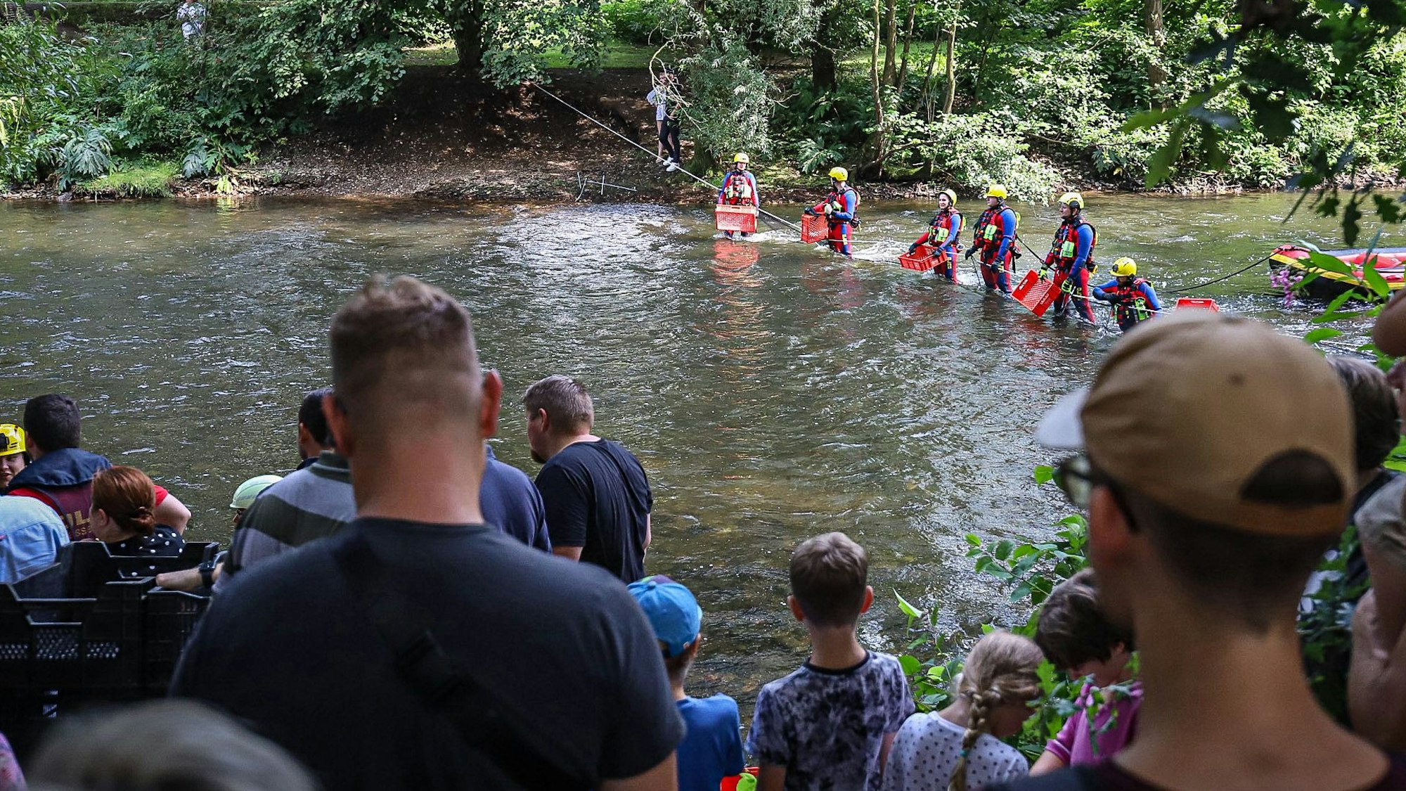 Helfer beim Entenrennen stehen in der Wupper.