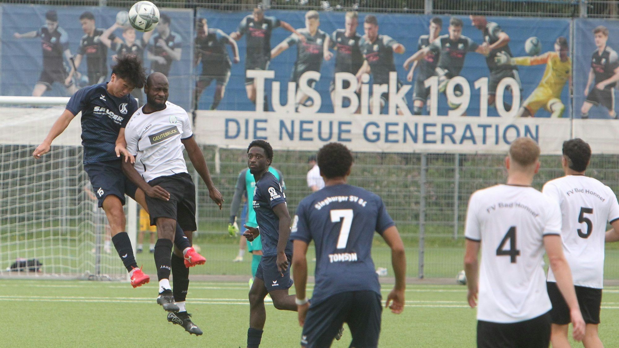 Augen zu und durch: Sora Yamato (links) vom Siegburger SV 04 und Asonganyi Defang vom HFV liefern sich auf der Anlage des TuS Birk ein Luft-Duell.