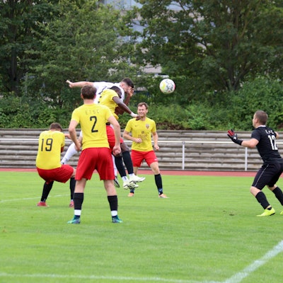 Ein Zülpicher Spieler springt nach einem Eckball hoch. Er ist umringt von Euskirchener Gegenspielern. Einer trifft ihn mit der Hand im Gesicht.