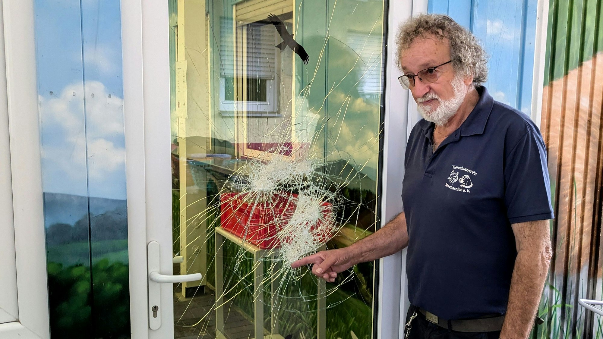 Reiner Bauer, Chef des Kreistierheims in Mechernich, zeigt Beschädigungen an einer Glastür, die bei einem Einbruch von einem Unbekannten verursacht wurden.