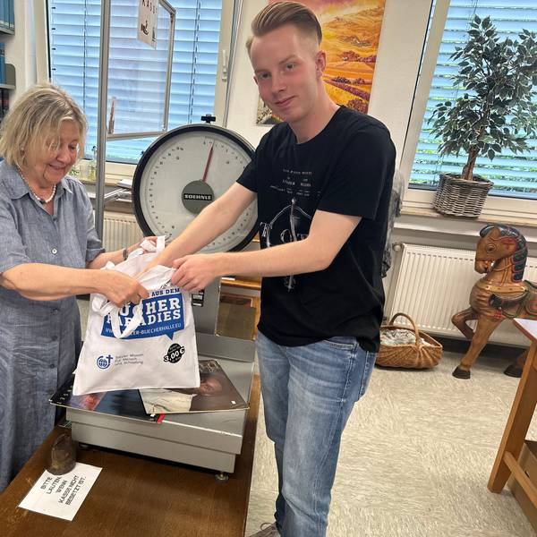 Gisela Lindner wiegt die Bücher, die Lehramtsstudent Jonathan Jungbluth gerade ausgesucht hat.