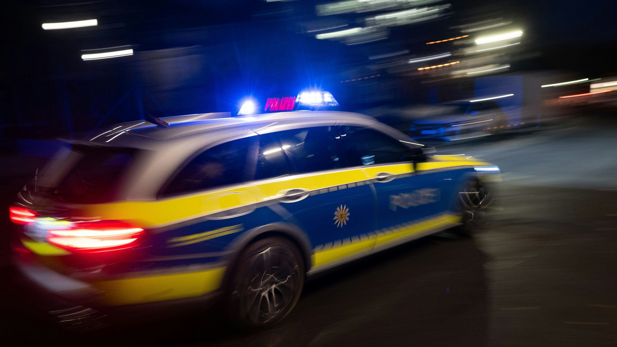 Polizeiauto fährt bei Dunkelheit vorbei