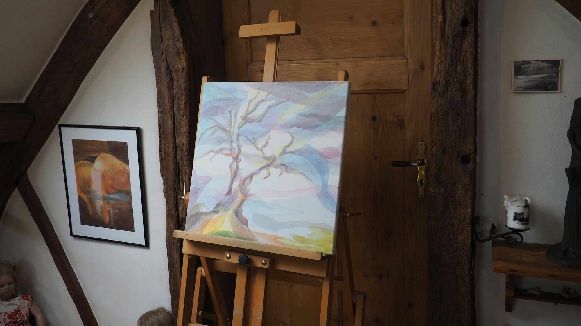 Ein Gemälde von Renate Lorentzen steht in Nettersheim auf einer Staffelei vor einer alten Holztür.