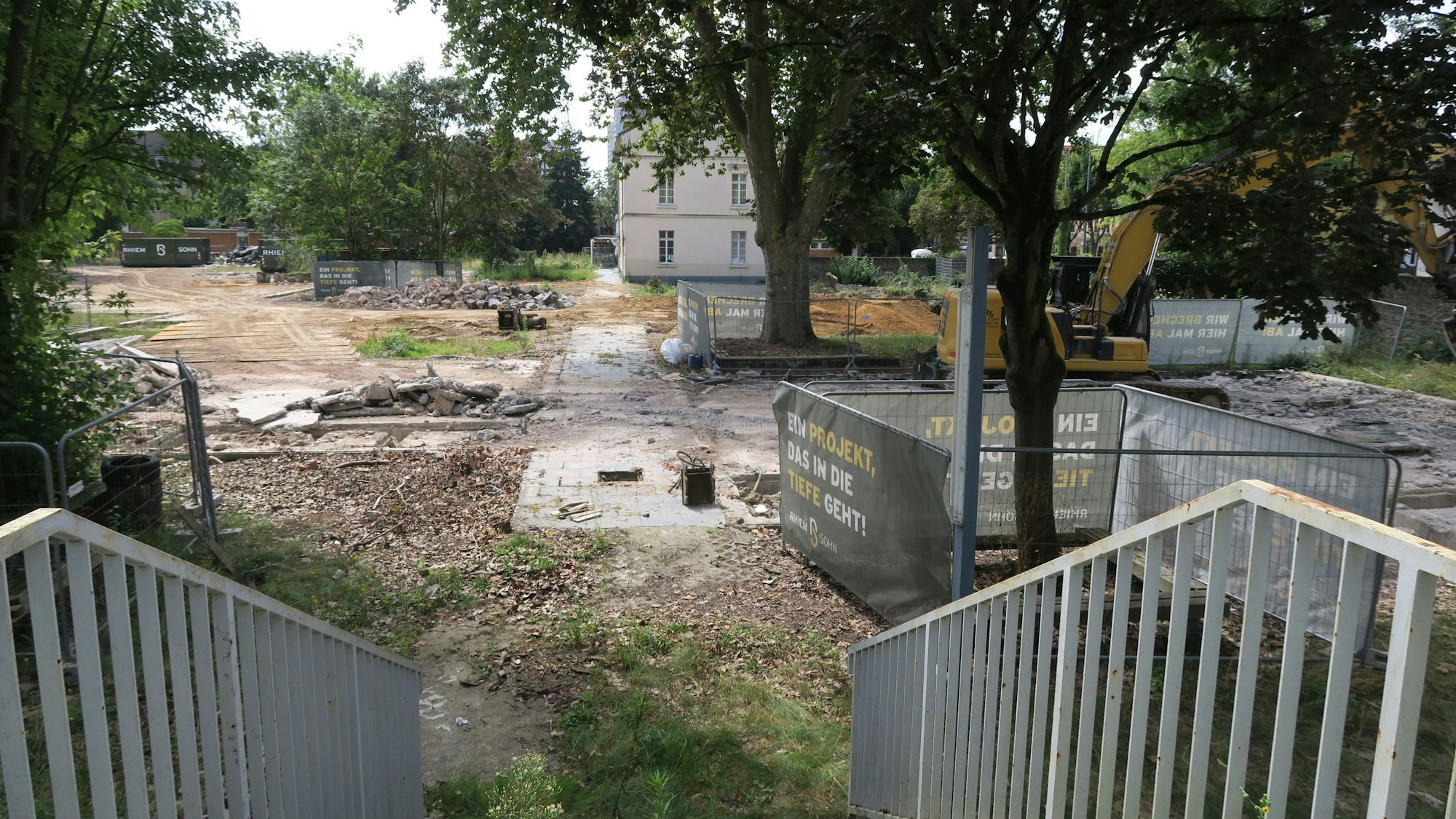 Blick auf eine fast komplett leere Grundstücksfläche. Vereinzelte Bäume stehen auf dem Gelände.