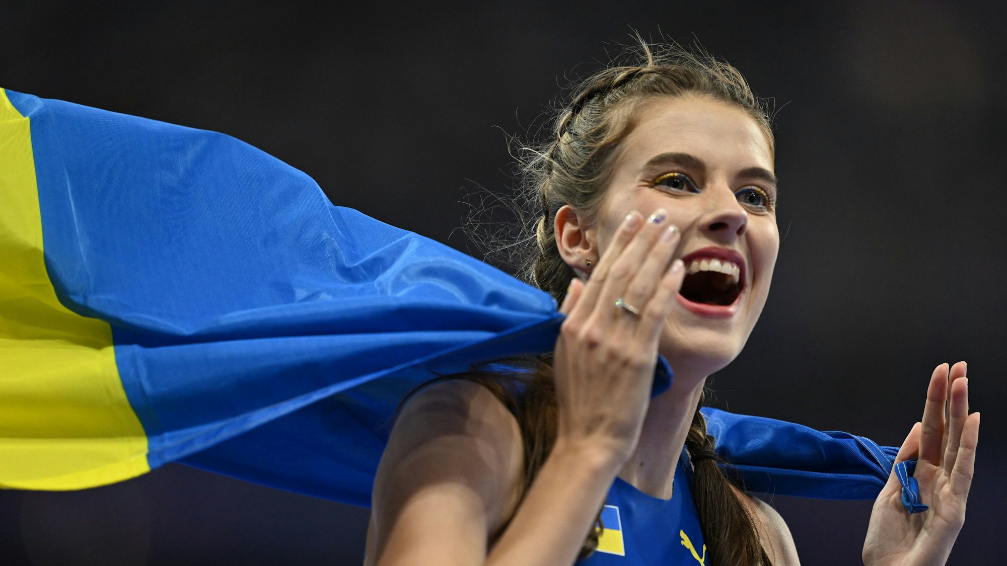 Jaroslawa Mahutschich aus der Ukraine feiert nach dem Wettbewerb. Sie trägt die Flagge der Ukraine um die Schultern.