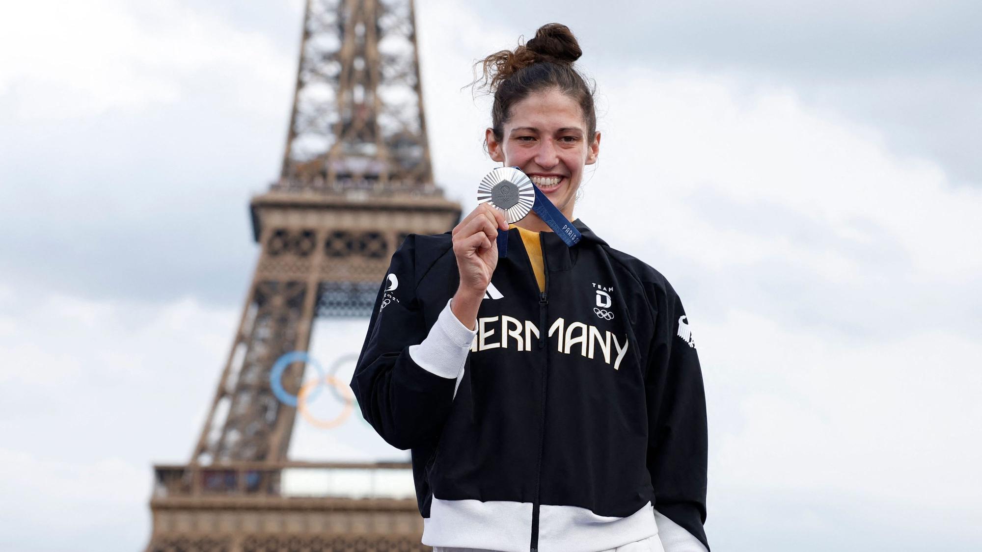 Miriam Butkereit hält die Silbermedaille in der Hand. Im Hintergrund ist der Eiffelturm zu sehen.