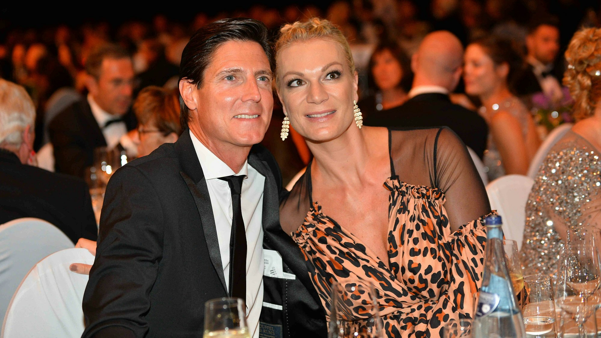 Maria Höfl-Riesch und ihr Ehemann Marcus Höfl lachen auf die Kamera.