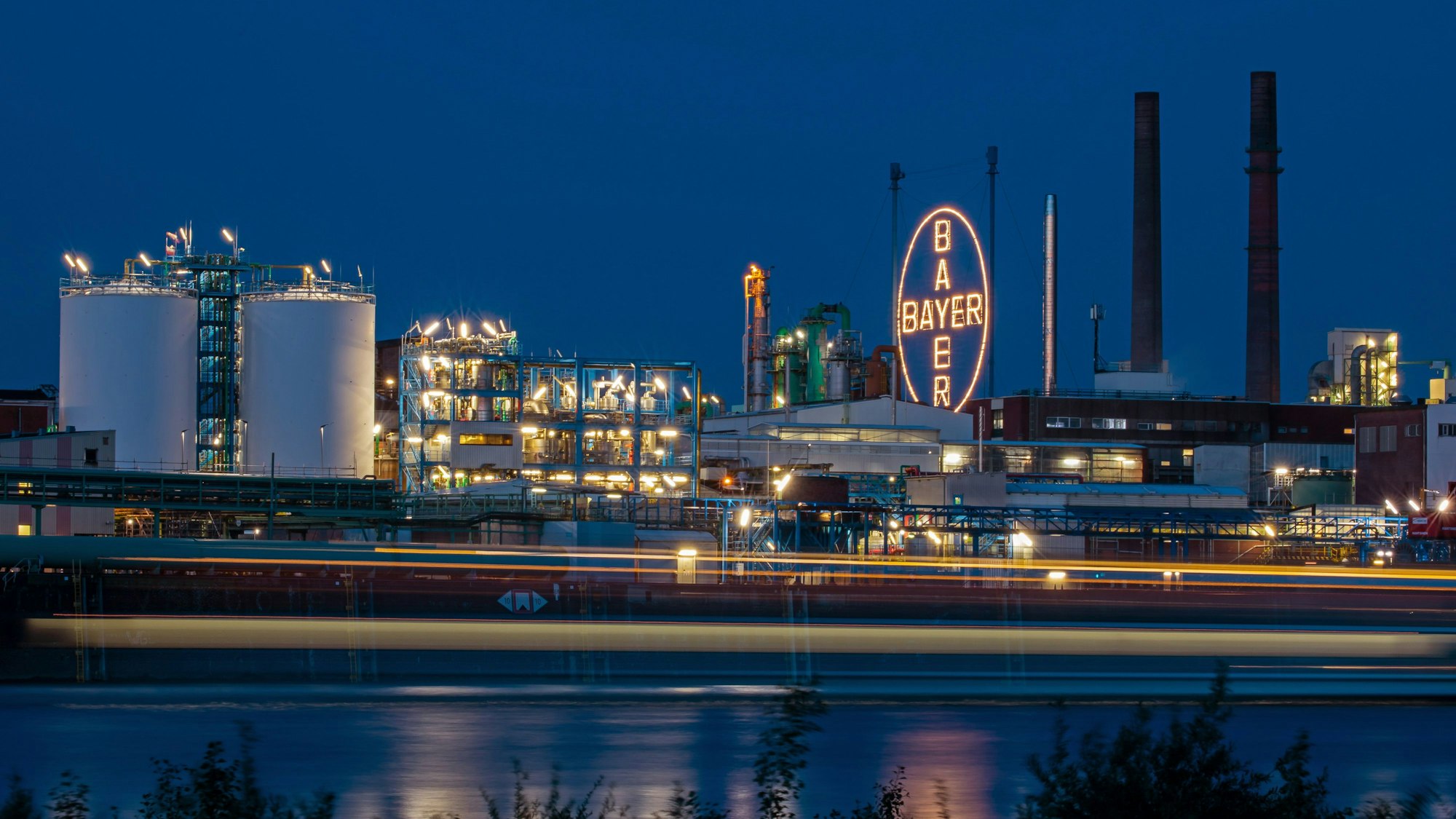 Das Bayer-Kreuz, das Logo des Unternehmens, leuchtet auf dem Werksgelände von Bayer in Leverkusen.
