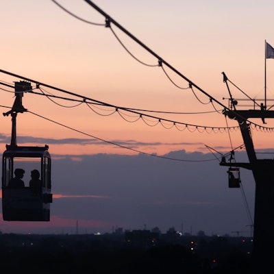 Bei einem orangeroten Himmel fährt die Kölner Seilbahn über den Rhein. In Köln könnten spätestens in der kommenden Woche nochmal mehr als 30 Grad erreicht werden. Erste Wettermodelle rechnen mit tropischen Temperaturen. (Symbolbild)