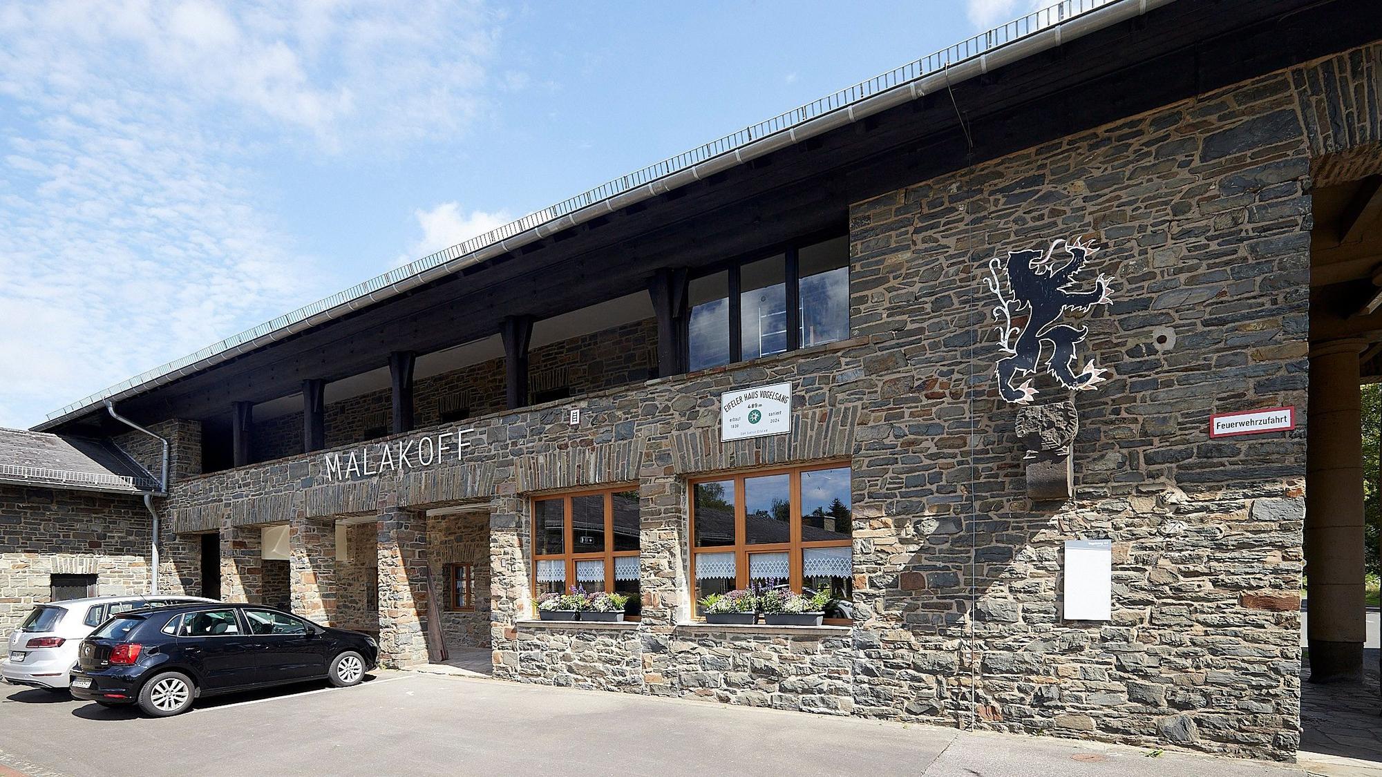 Der Schriftzug Malakoff prangt an einem alten Gebäude in Vogelsang, zwei Autos parken vor dem Haus. Einst war darin das Kasernengefängnis, nun ist dort ein Selbstversorgerhaus des Alpenvereins eingerichtet.