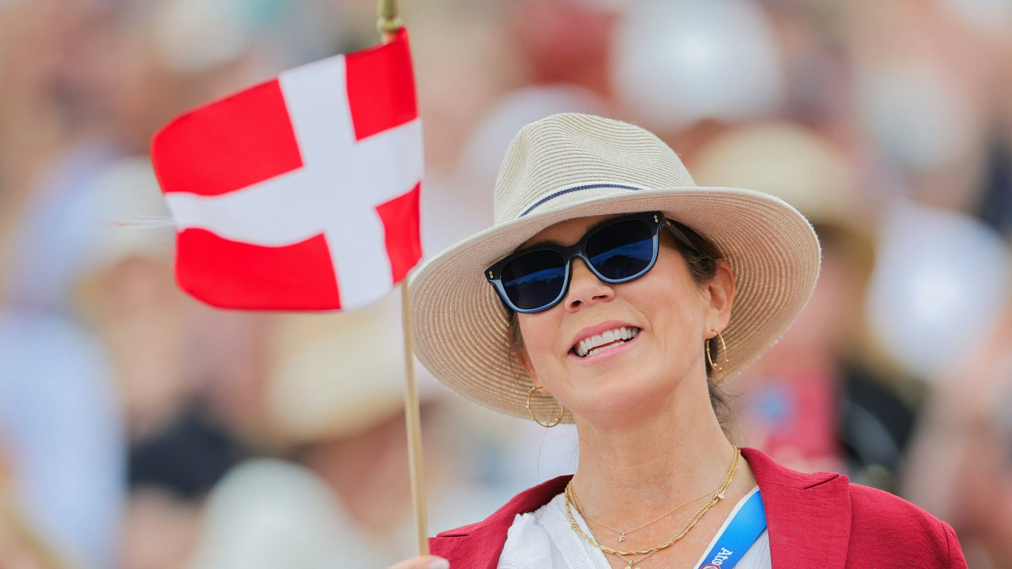 Königin Mary winkt mit der dänischen Flagge.