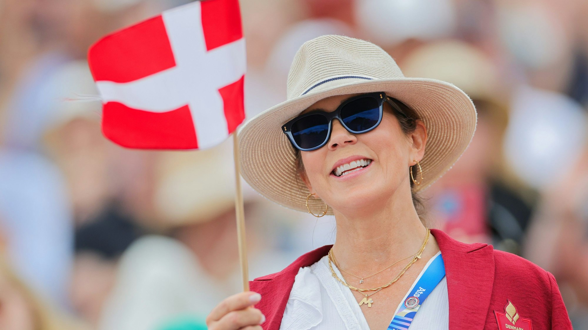 Königin Mary von Dänemark winkt mit einer Fahne.