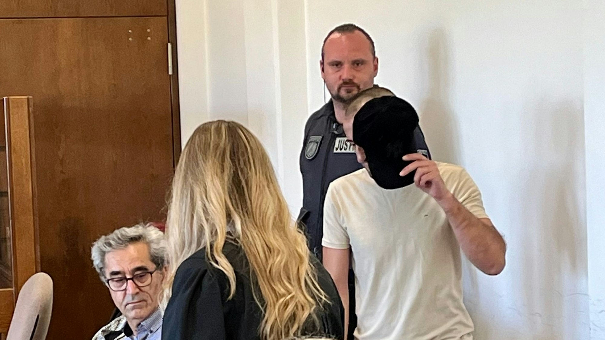 Der jüngere Angeklagte im Prozess um eine tödliche Messerstecherei in Schlebusch am 18. Februar 2024 betritt Saal 112 im Kölner Landgericht.