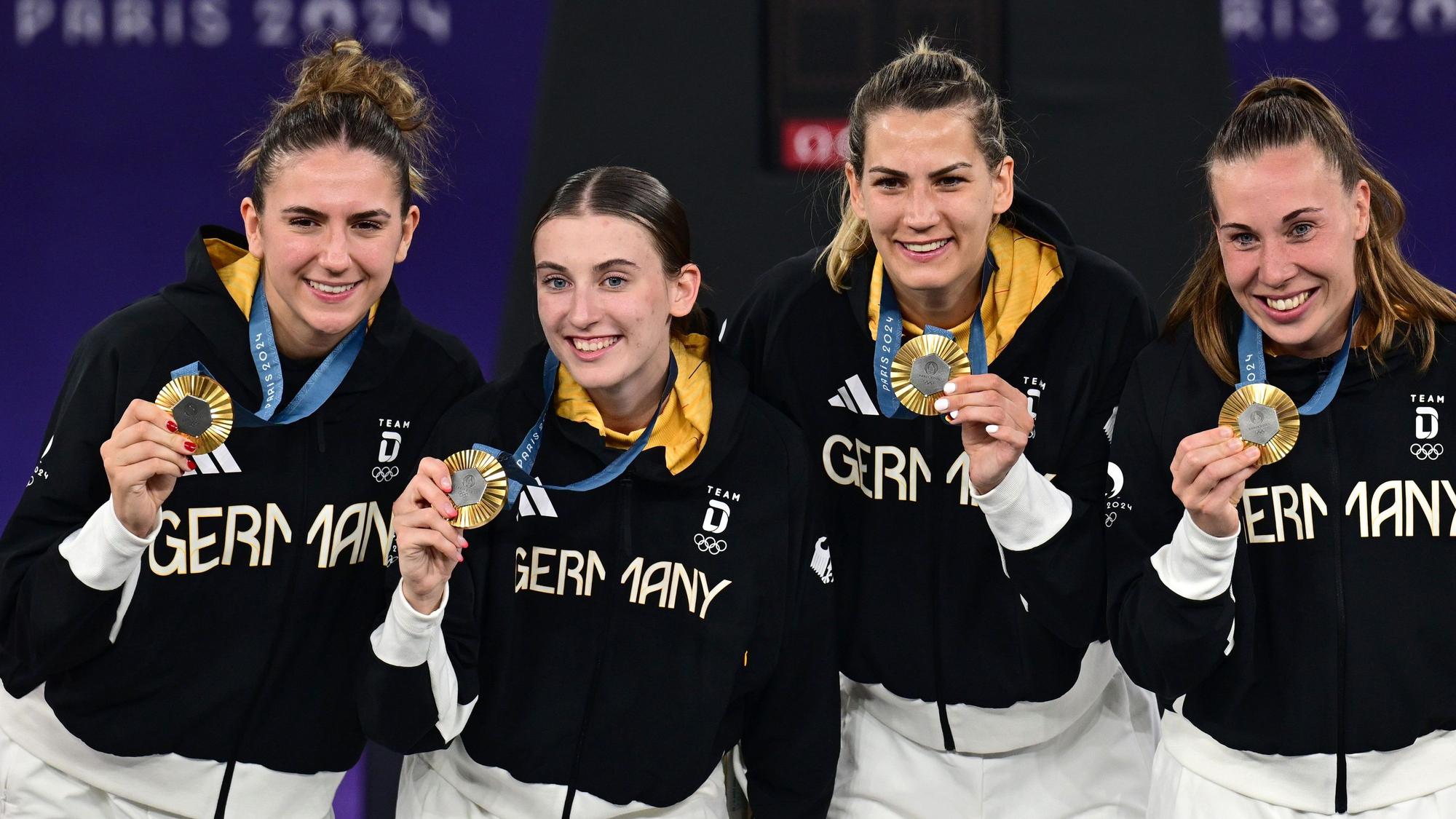 Marie Reichert, Elisa Mevius, Sonja Greinacher und Svenja Brunckhorst (v.l.n.r.) haben die erste deutsche Goldmedaille im Basketball bei Olympia gewonnen. An der ZDF-Übertragung gibt es scharfe Kritik.
