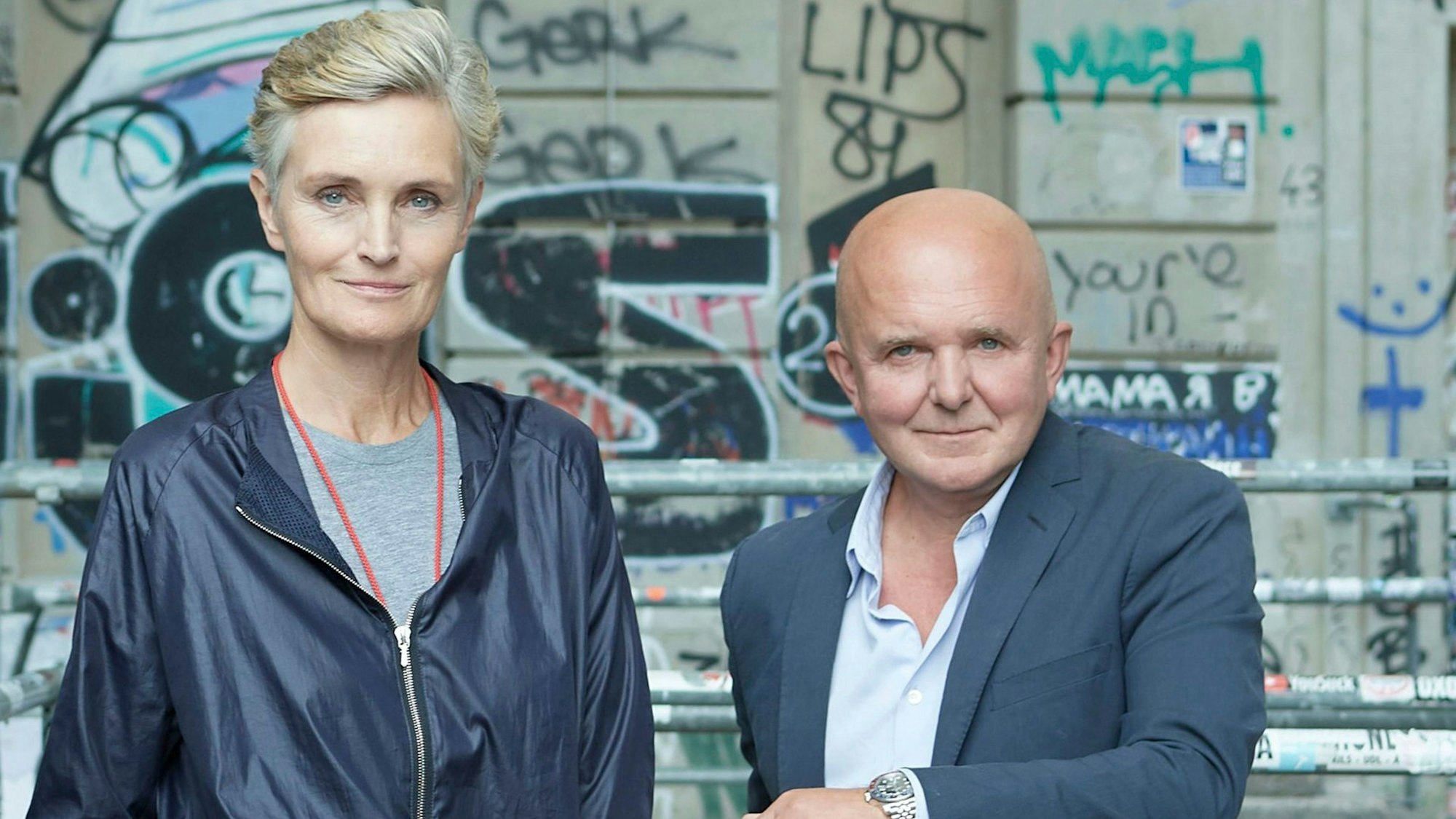 Karen und Christian Boros stehen vor einer Wand mit Graffiti.