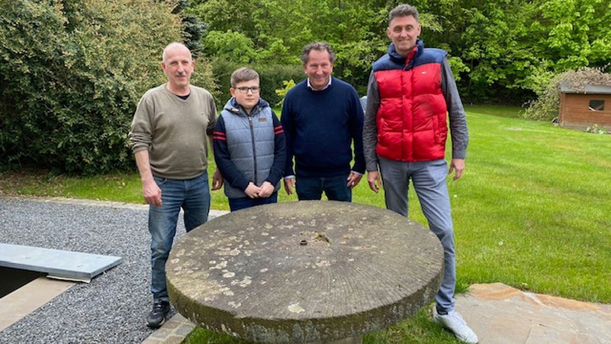 Vor dem alten Mühlstein (v.l.): Peter Schiffbauer mit Sohn Jonas, Frank Schiffbauer, Stefan Christl vom Arbeitskreis Regionalgeschichte.
