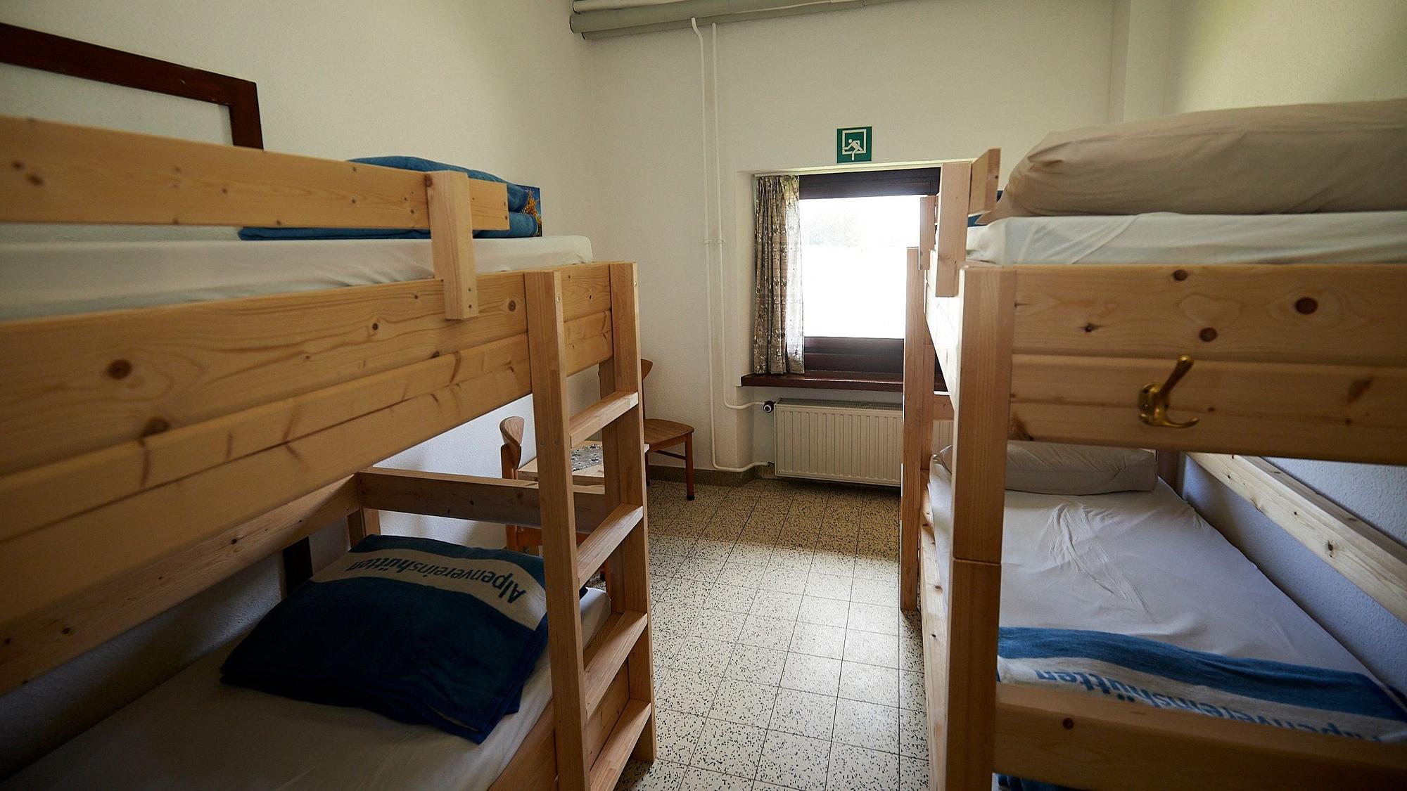 Zwei Stockbetten aus hellem Holz bieten in einem Vierbettzimmer der Alpenvereinshütte in Vogelsang Schlafmöglichkeiten.