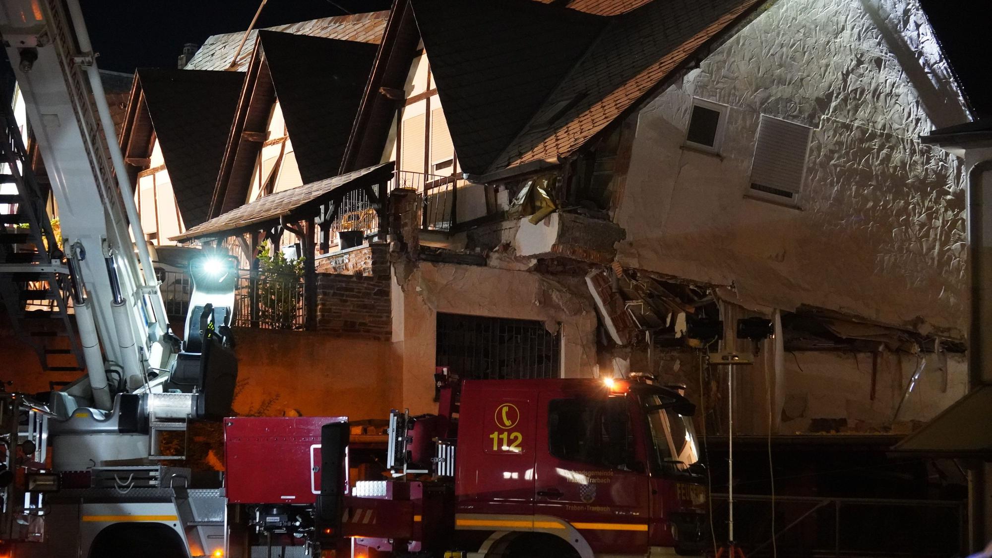 Ein Fahrzeug der Feuerwehr steht vor einem eingestürzten Hotel.