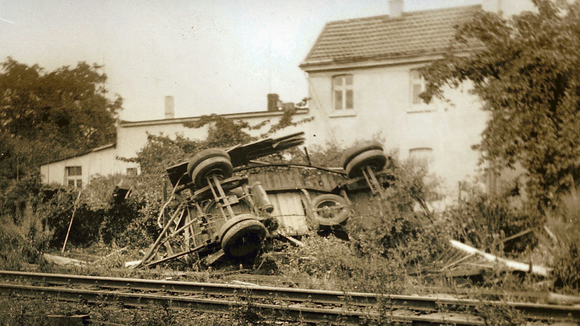 Ein schwarz-weiß Foto zeigt den mitgerissenen, völlig zerstörten Anhänger.