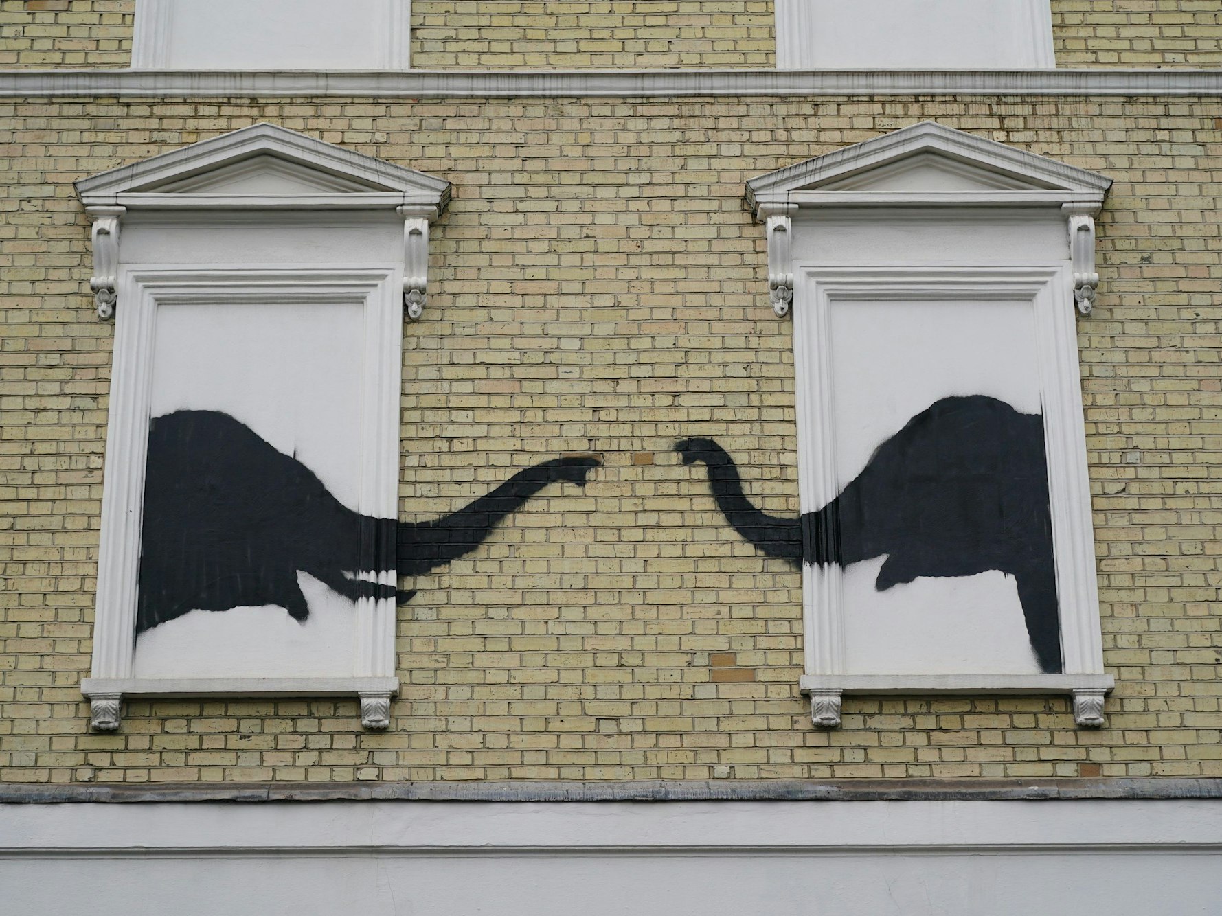 Wieder wird ein neues Kunstwerk von Banksy in London gesichtet. Die schwarzen Silhouetten zweier Elefanten strecken ihre Rüssel aus zwei Scheinfenstern eines Hauses an der Kreuzung Edith Grove und Edith Terrace in Chelsea im Südwesten von London.