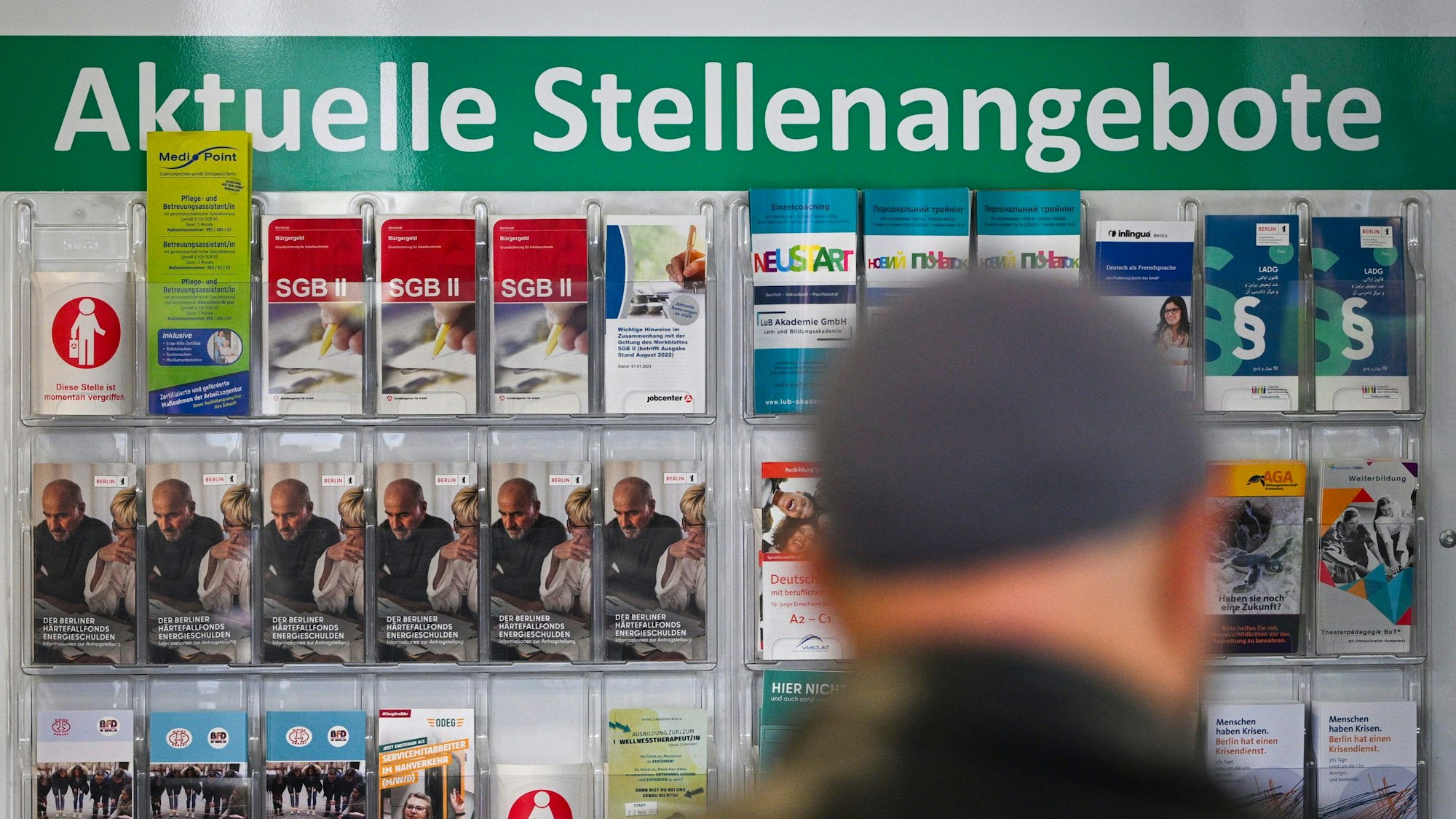 Flyer werden auf einer Tafel mit der Überschrift ·Aktuelle Stellenangebote· im Jobcenter Berlin Mitte am Tag der Möglichkeiten angeboten.