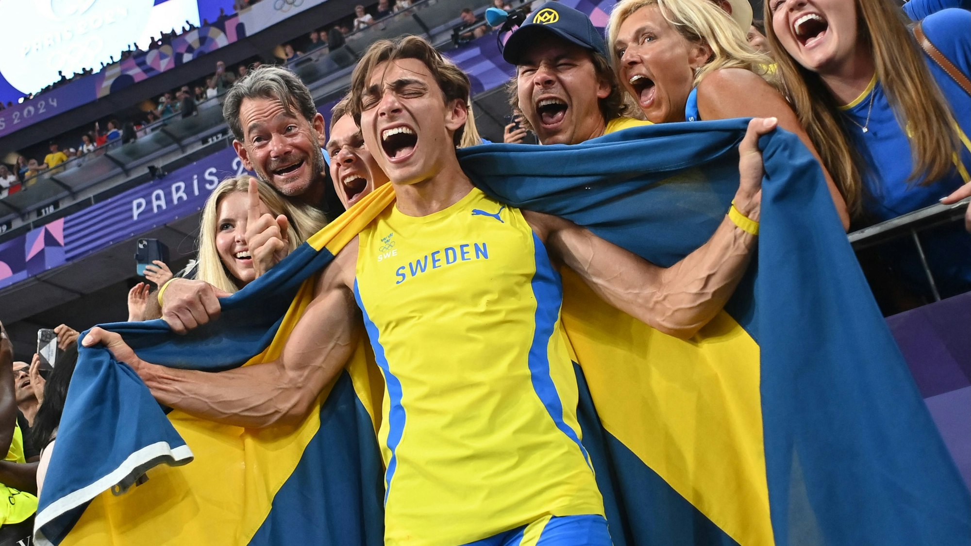 Armand Duplantis jubelt ausgelassen mit seinem Anhang nach seinem Olympiasieg.
