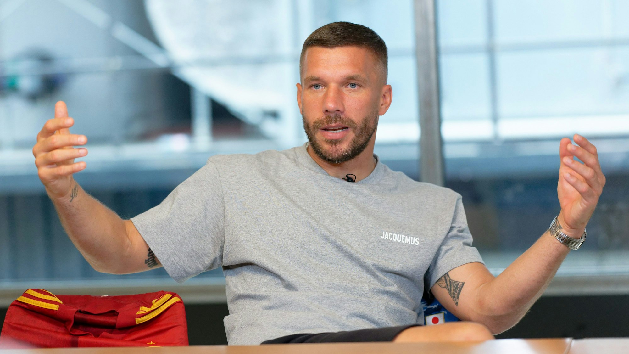 PRODUKTION - 15.07.2024, Nordrhein-Westfalen, Köln: Der Fußballprofi Lukas Podolski sitzt bei einem Interview in einem Besprechungsraum. (zu dpa: «Podolski plant vorzeitiges Abschiedsspiel») Foto: Henning Kaiser/dpa +++ dpa-Bildfunk +++