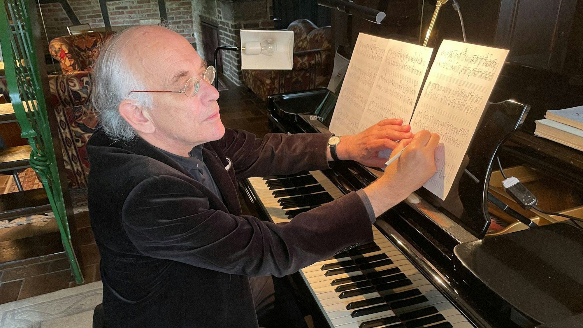 Dirk Joeres sitzt am Flügel und notiert etwas in seinen Noten.