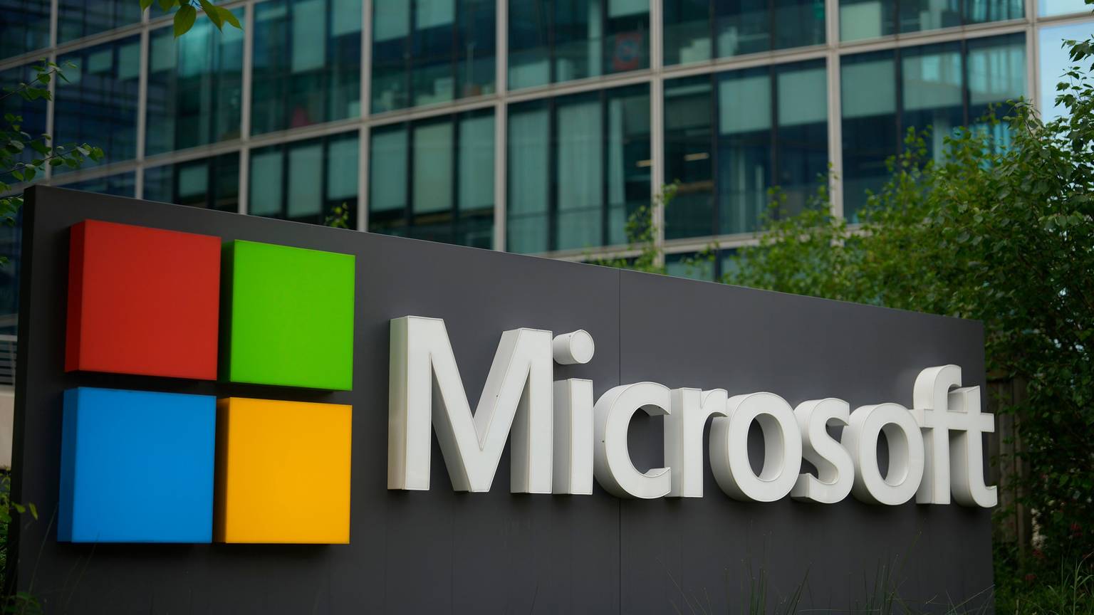 Das Logo von Microsoft ist vor einem Firmensitz zu sehen.