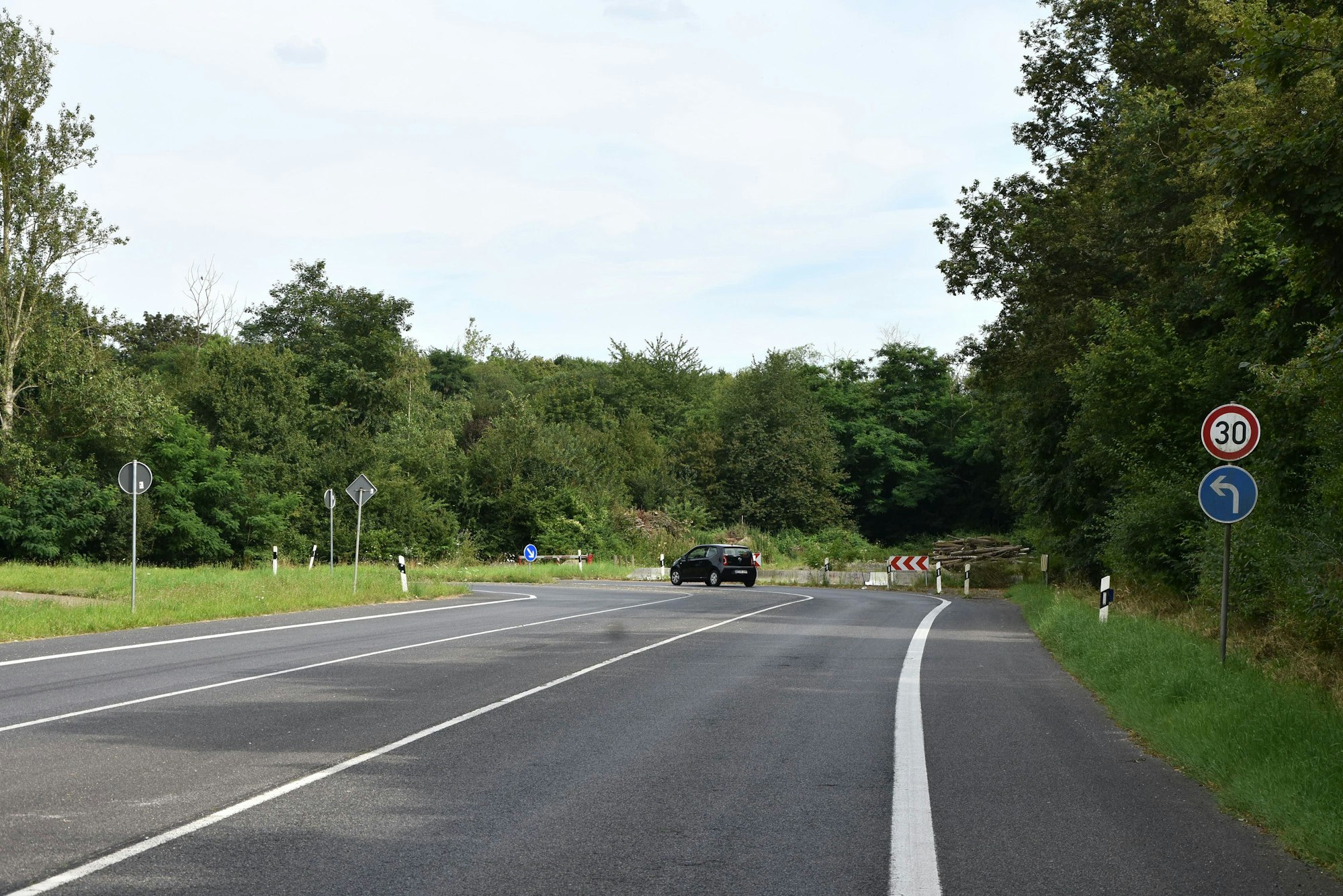 Auf einer Straße steht eine Absperrbake, dahinter ist noch ein Stück der Straße zu sehen, die dann aber abrupt endet.