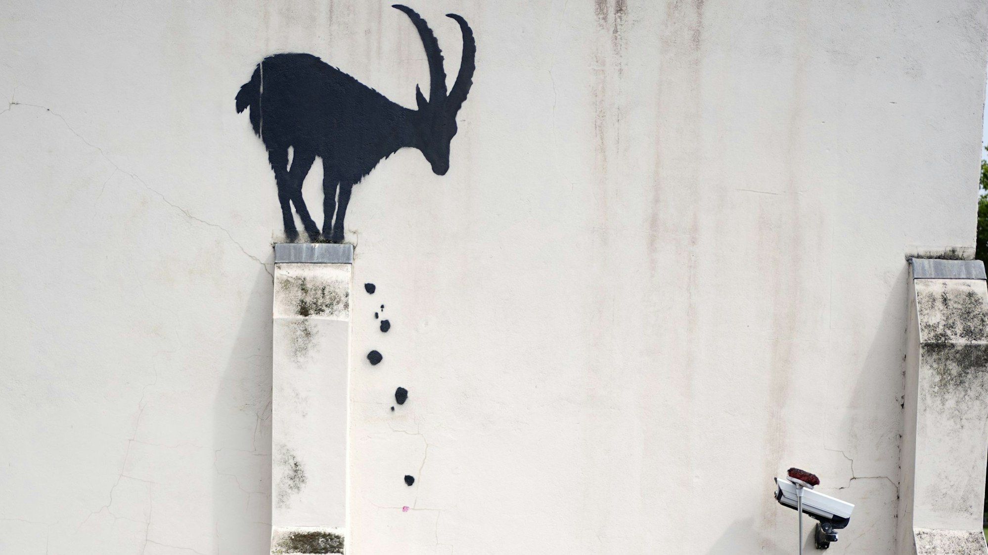 Mitarbeiter bringen eine Überwachungskamera an einer Hauswand in der Nähe der Kew Bridge im Westen Londons wieder in ihre ursprüngliche Position, nachdem der Künstler Banksy sie verschoben hatte, um an dieser Hauswand sein neuestes Kunstwerk zu gestalten: die Silhouette eines Steinbocks.